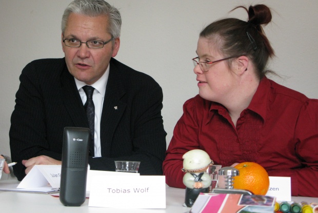 Angela Fritzen and Hubert Hüppe sitting at a table and talking.